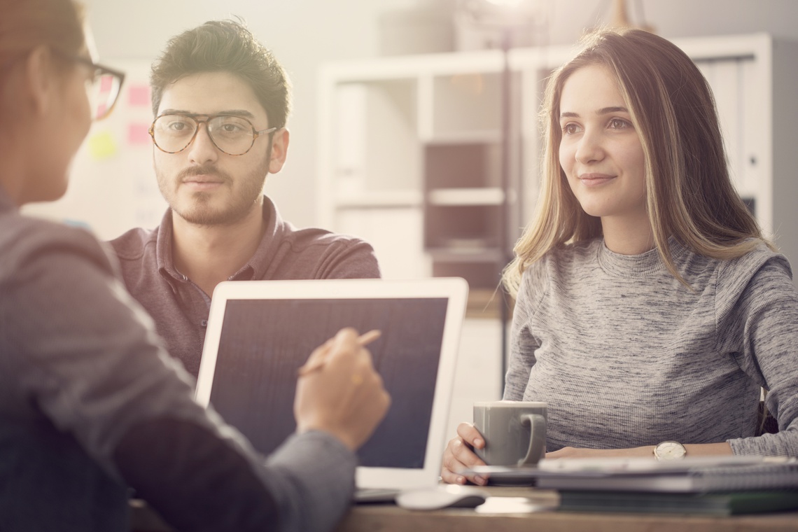 Portrait picture of Couple sitting at desk discussing options for financing